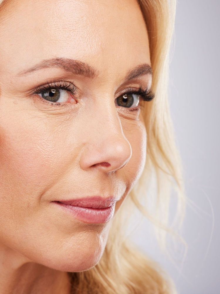 Woman with radiant skin touching face - Revlon Age Defying 3X Foundation