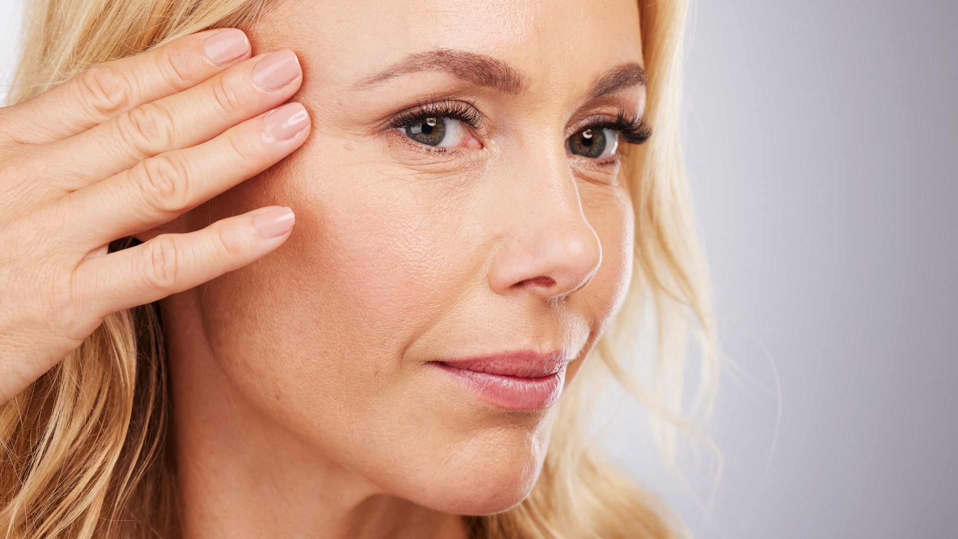 Woman with radiant skin touching face - Revlon Age Defying 3X Foundation